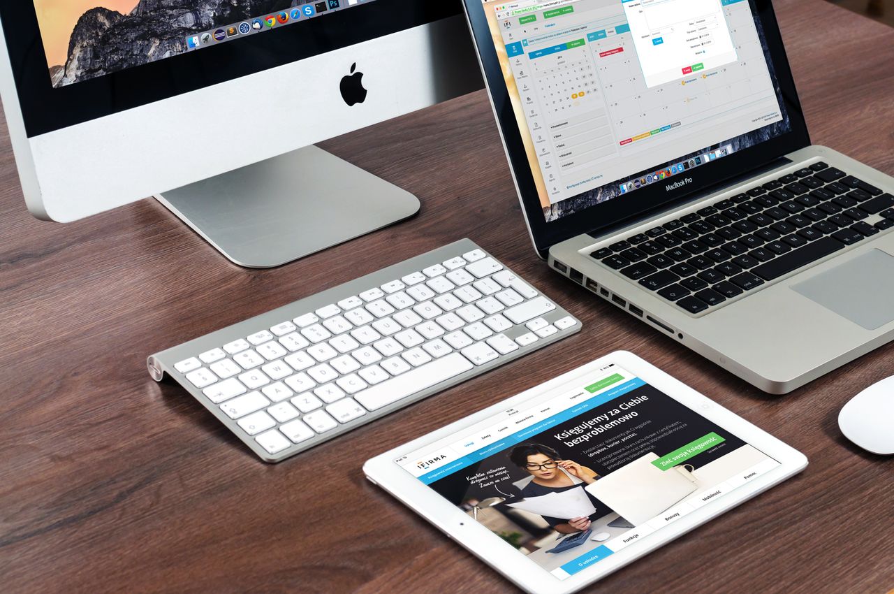why-choose-us Un élégant bureau de travail avec des appareils Apple : iMac, MacBook et iPad.